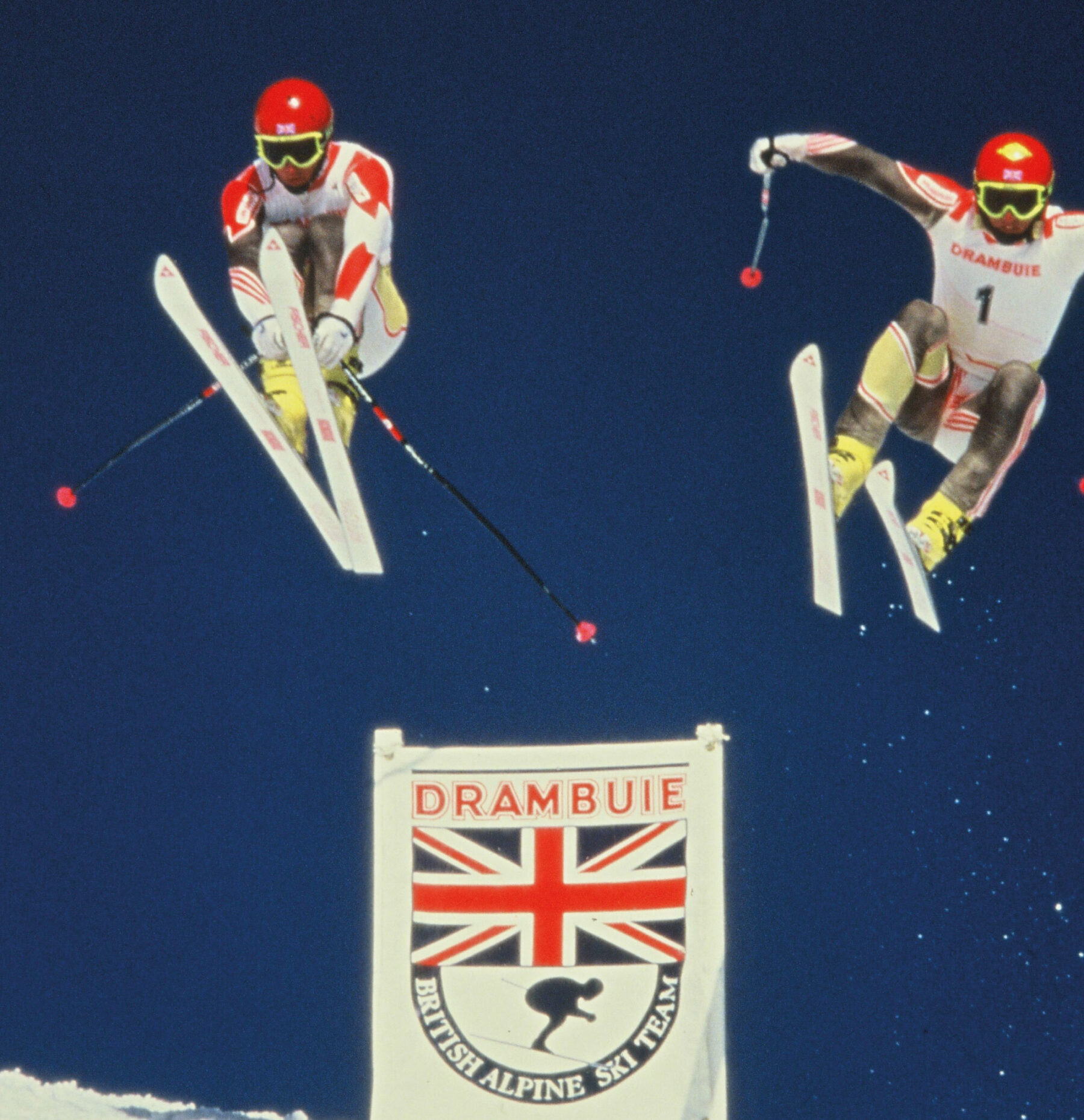 2 of the British ski team jumping. Against a dark blue sky in suits sponsored by Drambuie and designed by Gail while working at Newell and Sorrell.