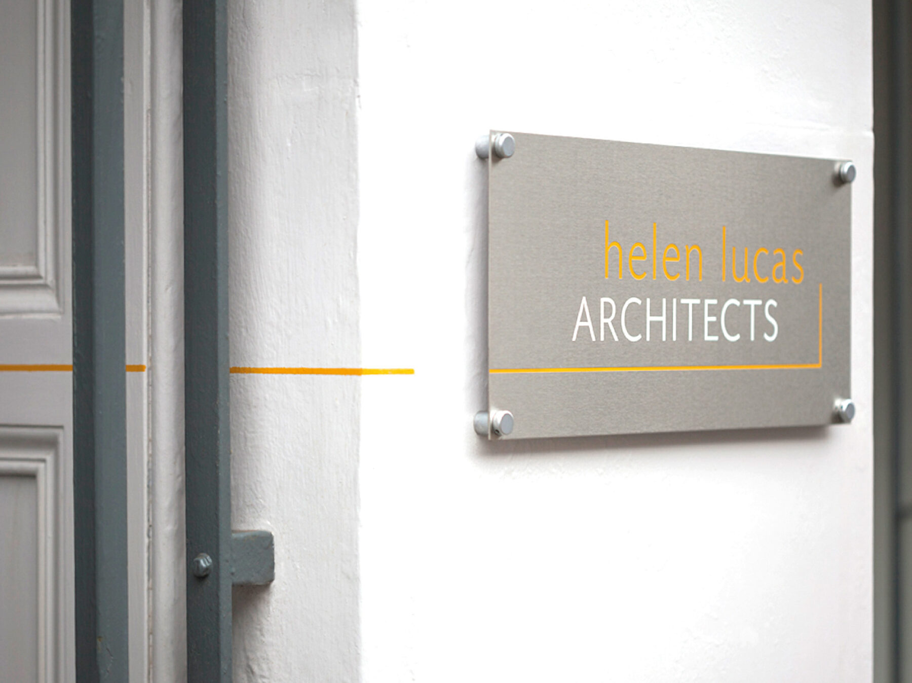 Photo of Helen Lucas Architects exterior metal sign with logo.